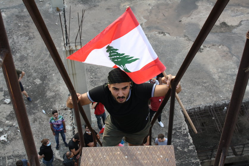Joven subiendo con la bandera de Líbano por unas escaleras
