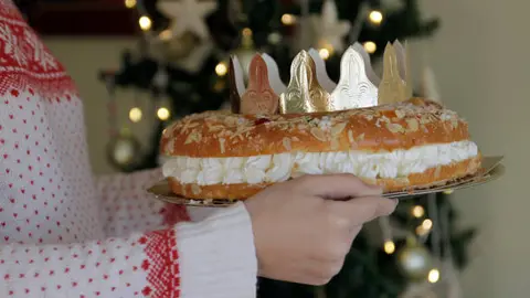 Mujer sosteniendo un Rosc&oacute;n de Reyes con una corona. Foto: gettyimages