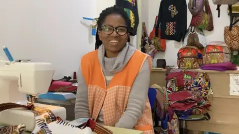 Clotilde en su tienda &ldquo;Yennega, &Aacute;frica&rdquo;, cosiendo complementos con telas de su pa&iacute;s. Imagen_F&aacute;tima Carrillo