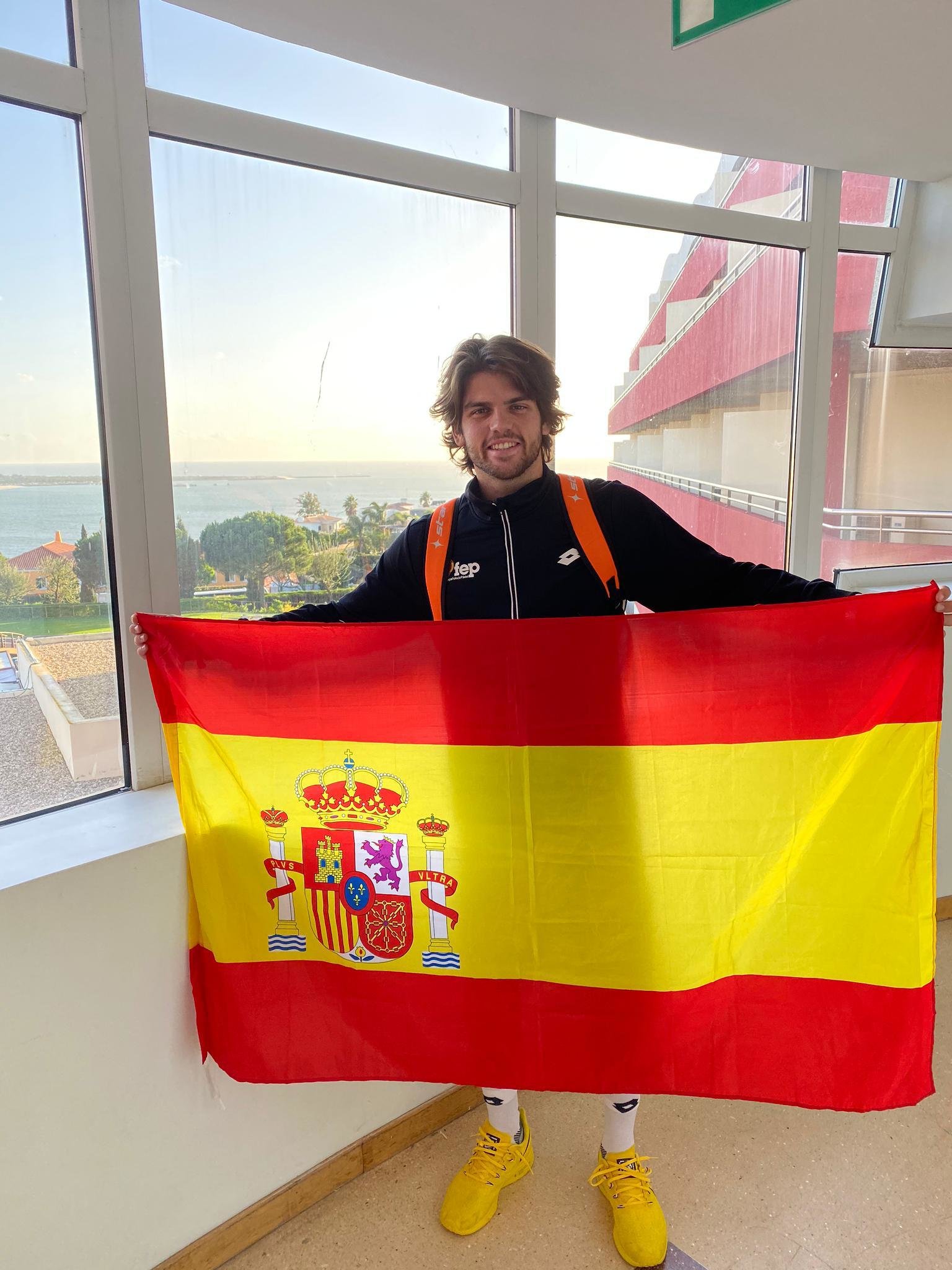 Javier Garrido sujetando al bandera de España al aterrizar en Lisboa.